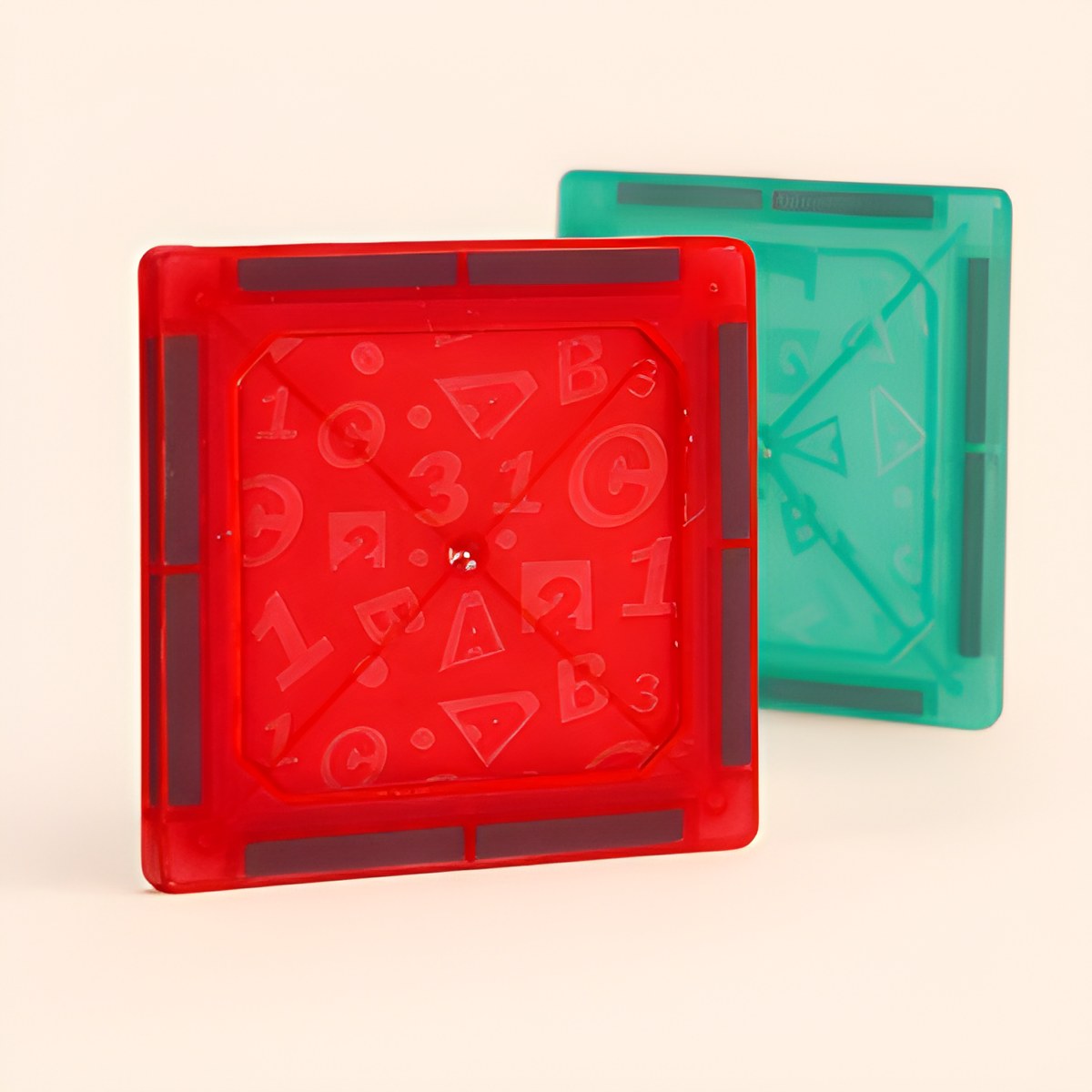 Deux blocs magnétiques, un rouge et un vert, avec leurs motifs de chiffres et lettres embossés